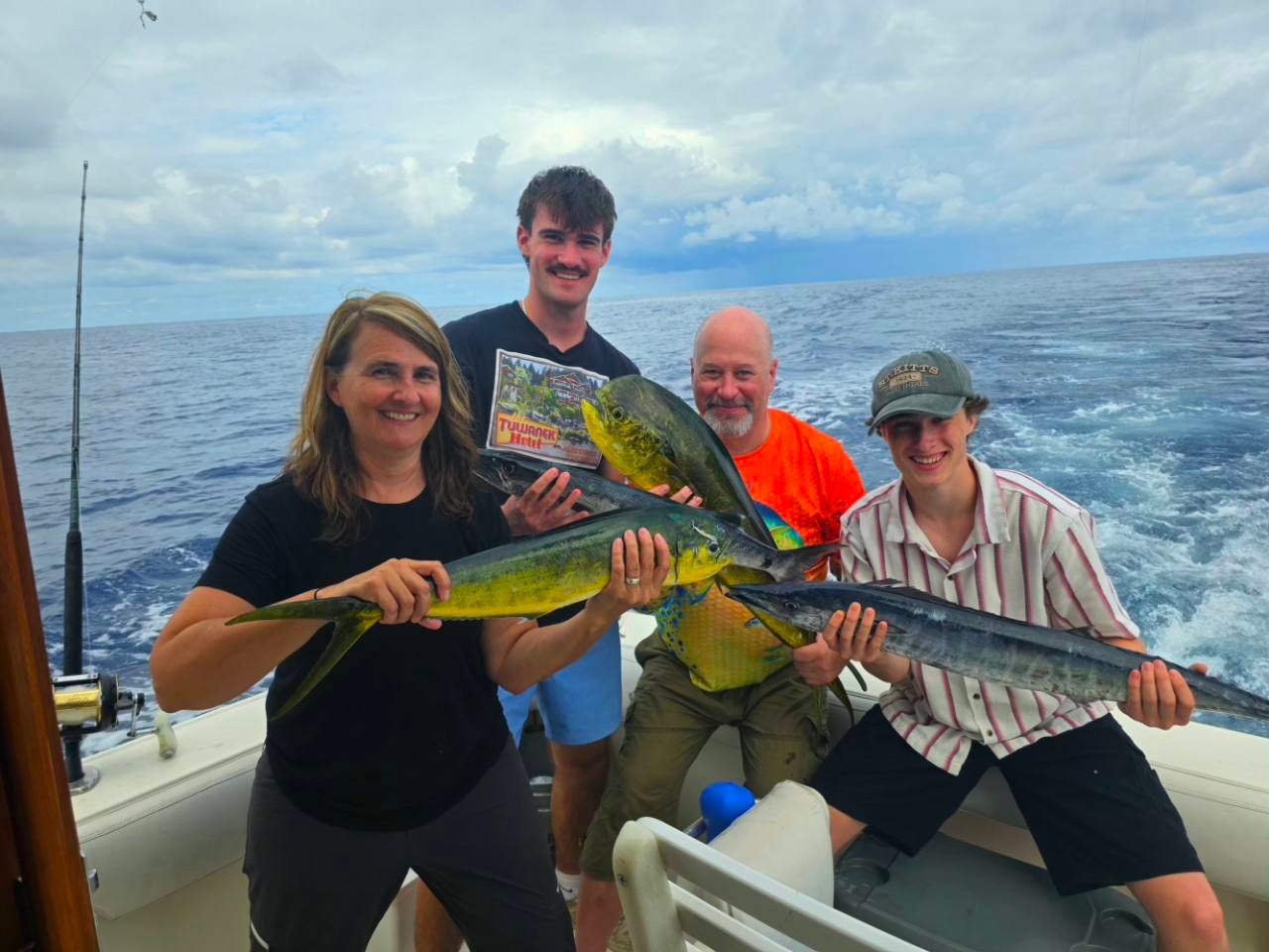 Four family members display mahi and wahoo during a High Z's fishing trip