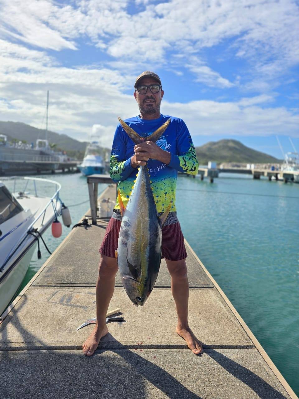 A High Z's crew member holds a large tuna at Ocean World Marina